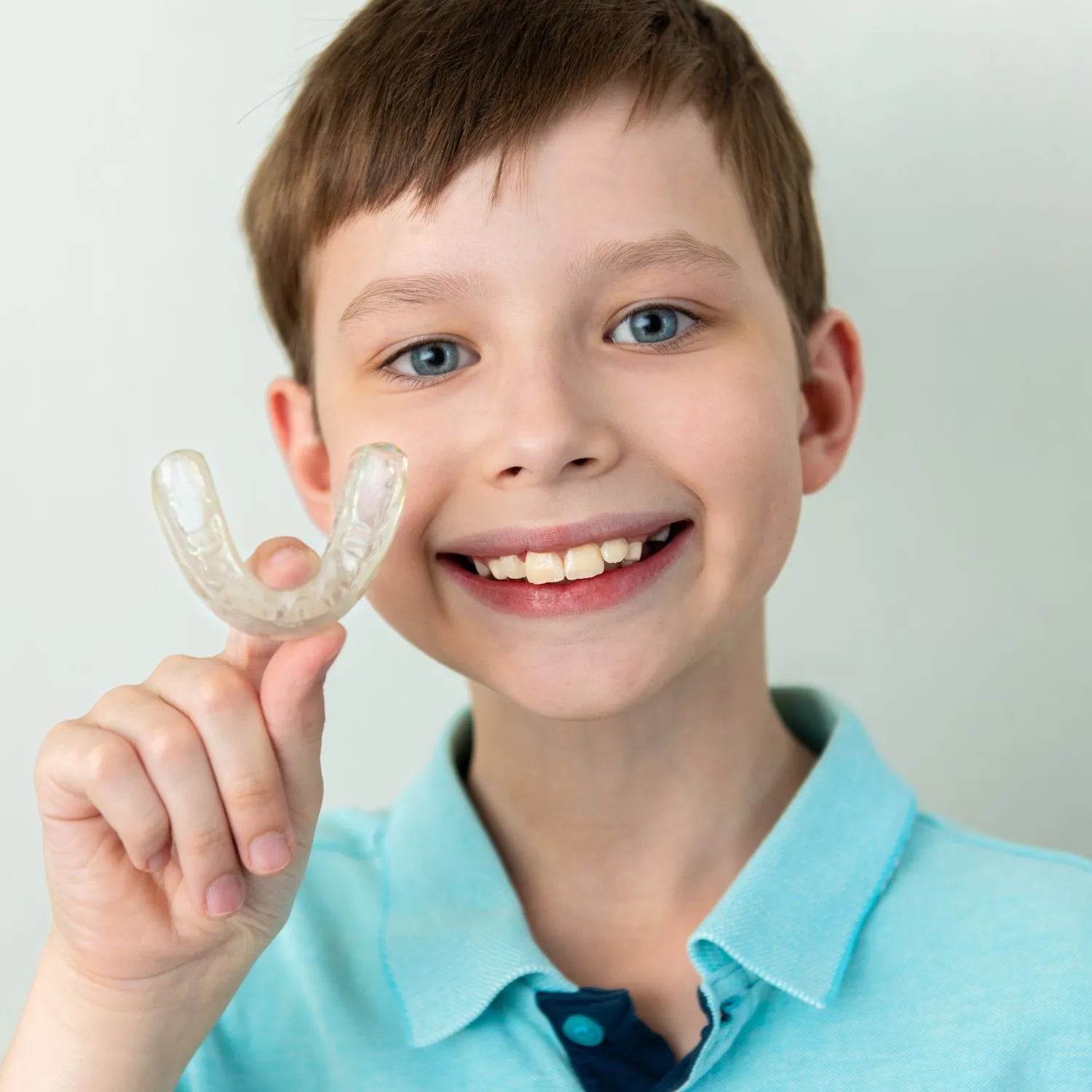 boy smiling showing his Invisalign first aligner