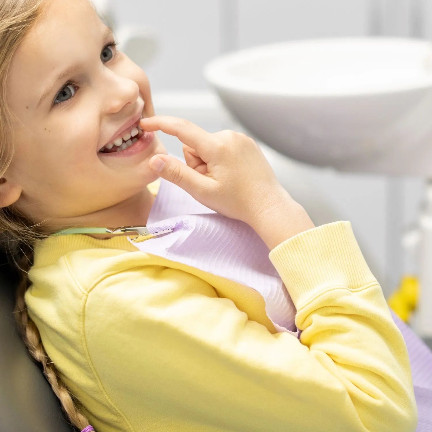 Child in a dental chair showing her teeth to the orthodontist