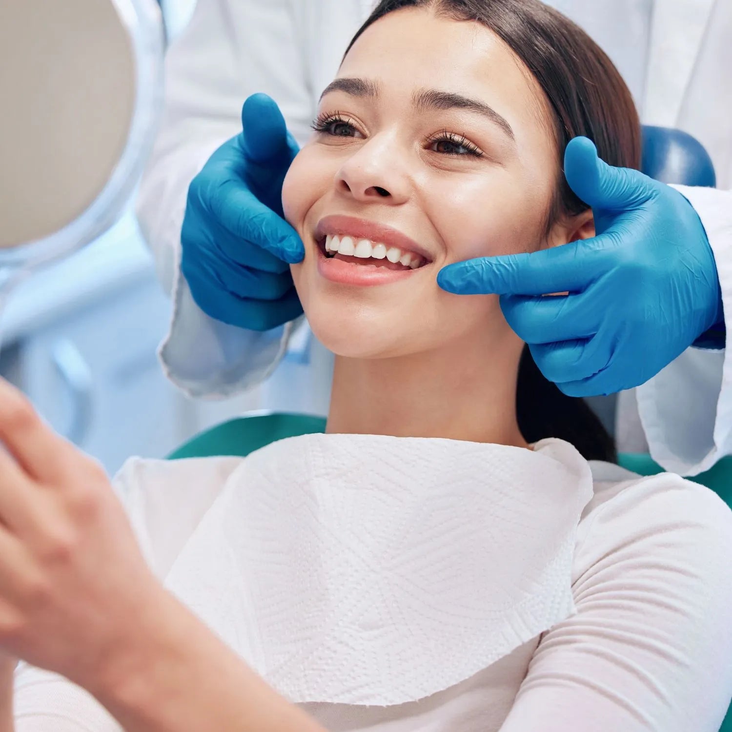 female patient with her dentist looking at her teeth in a mirror