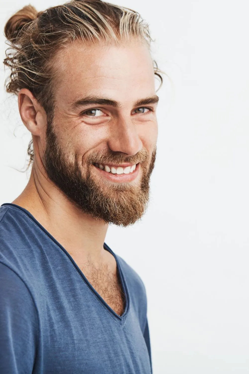 man smiling at camera wearin a bleu tee shirt