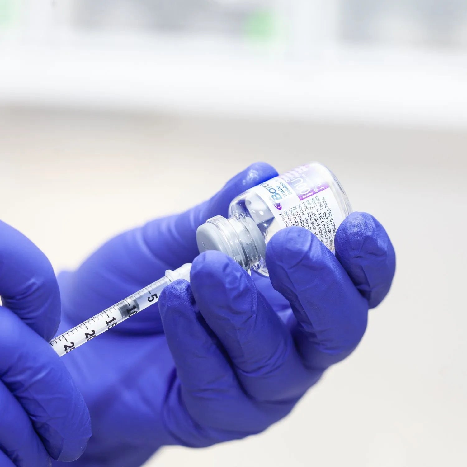 syringe drawing botox out of the bottle