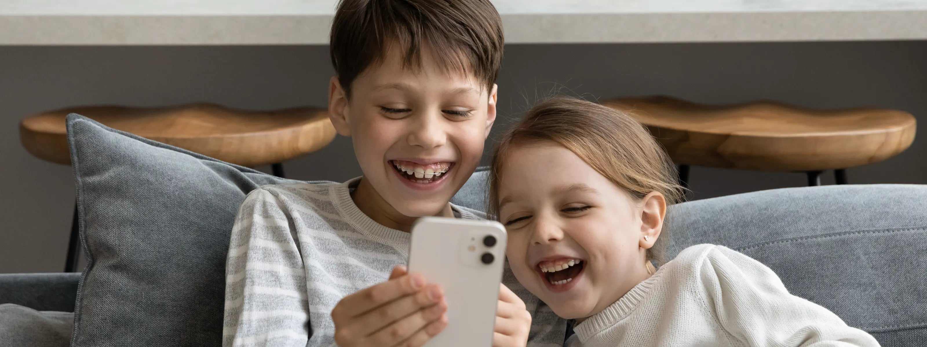 children smiling looking at a mobile phone