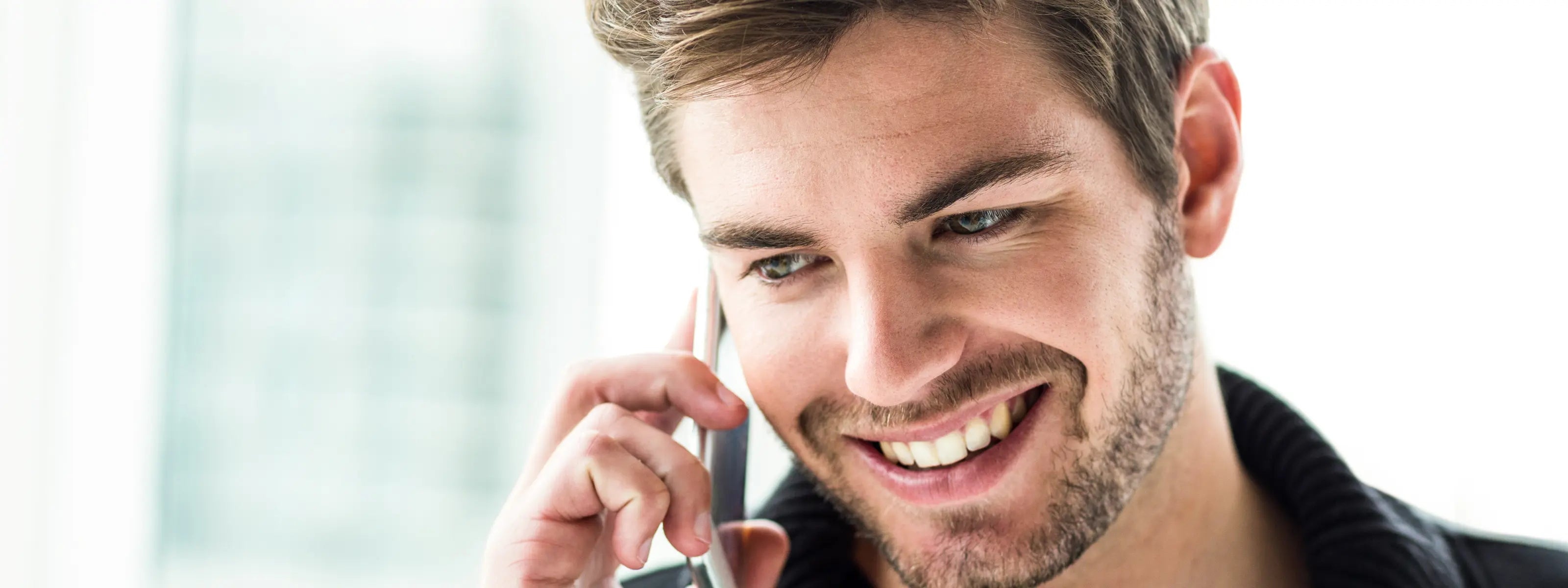 Close up young man with a beautiful smile  speaking on the phone