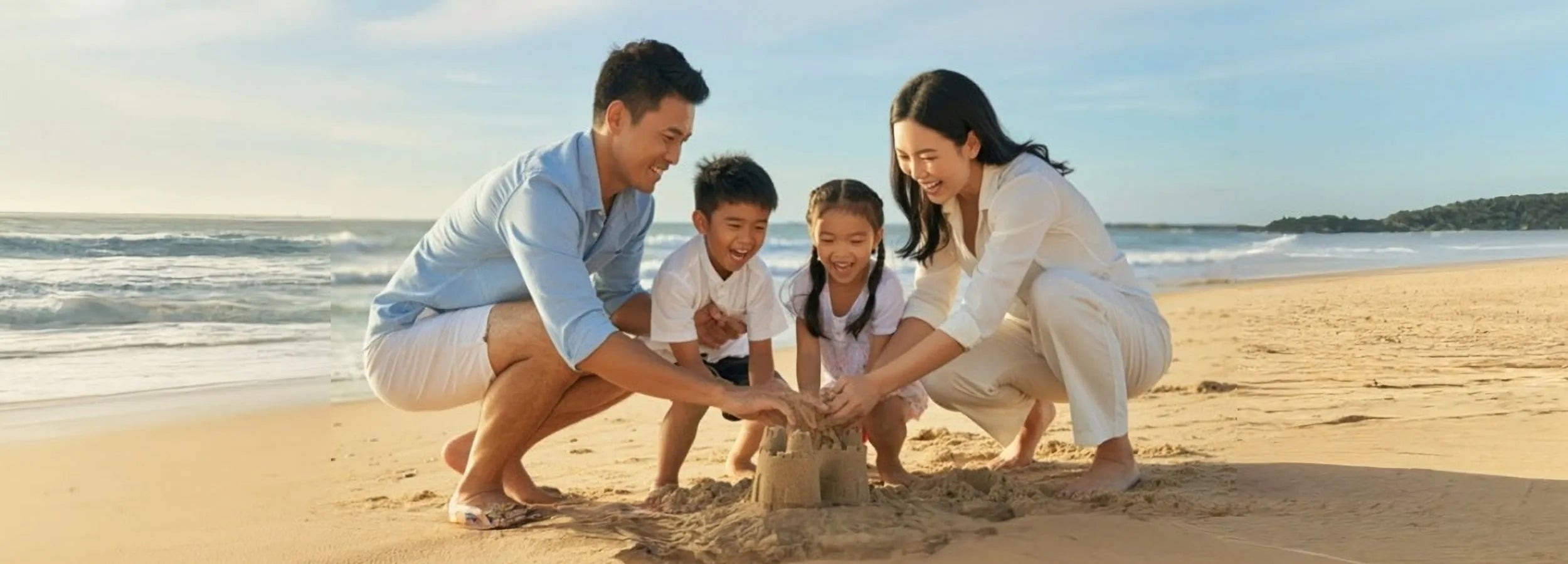 family with parents and two children playing on the seaside