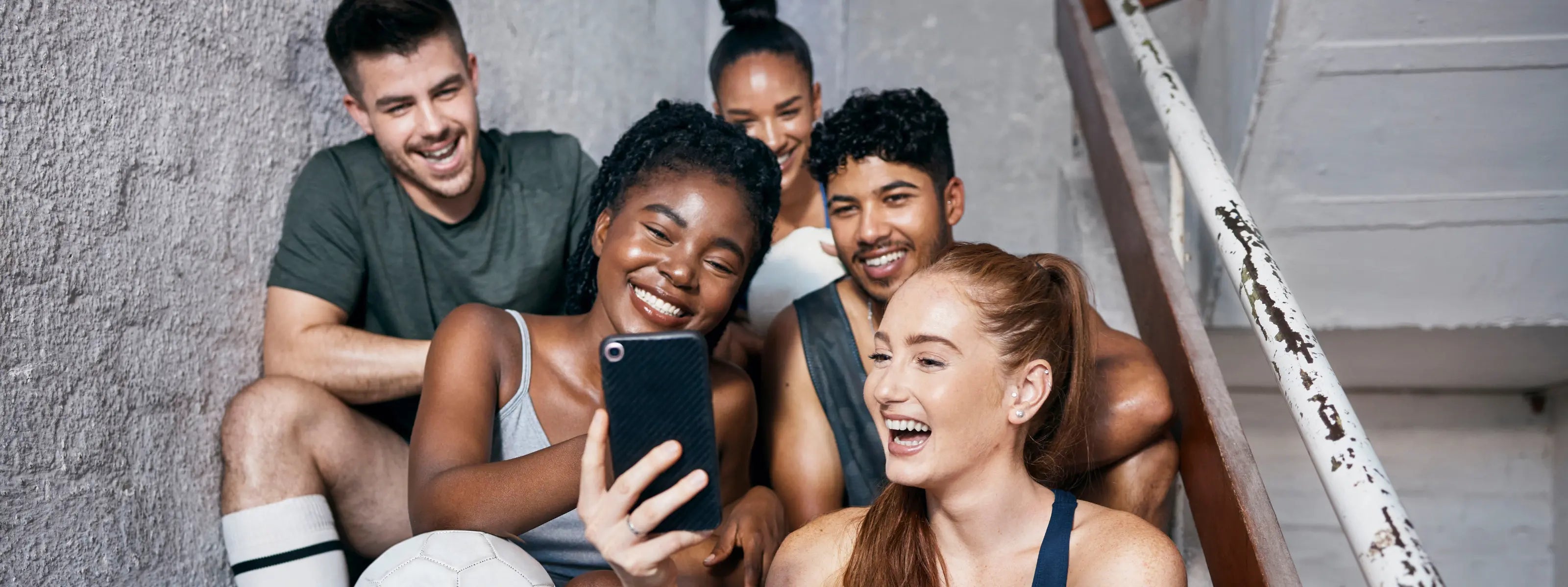 teenagers smiling looking at a picture on a mobile 