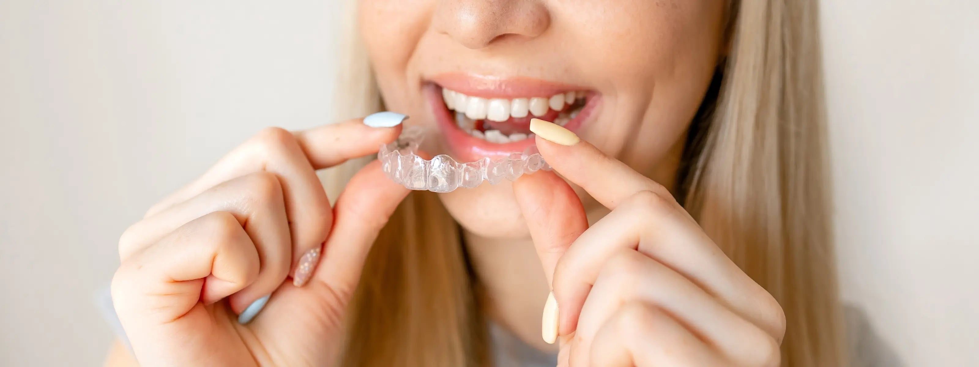 half face woman smiling showing her invisalign clear tray