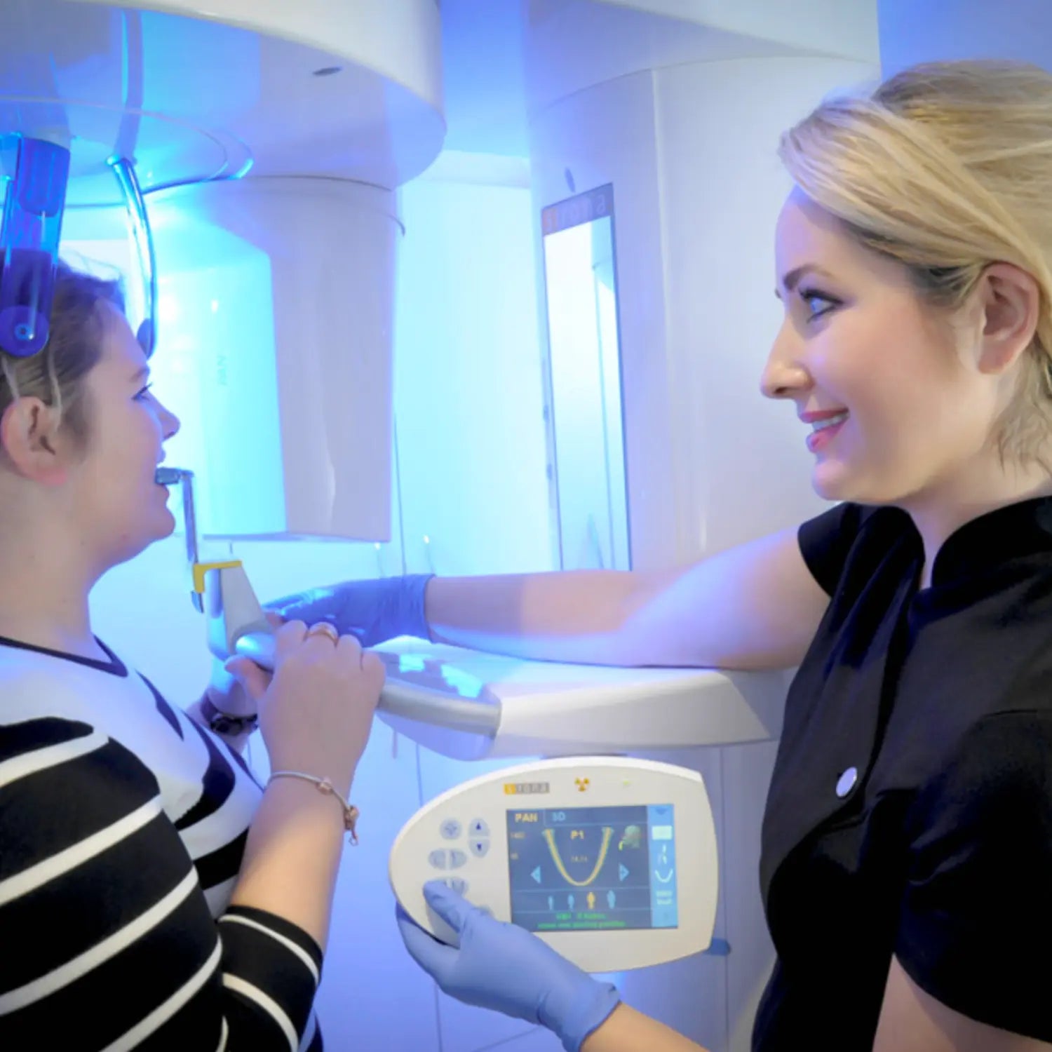 assistant  setting up patient to have a panoramic x-ray