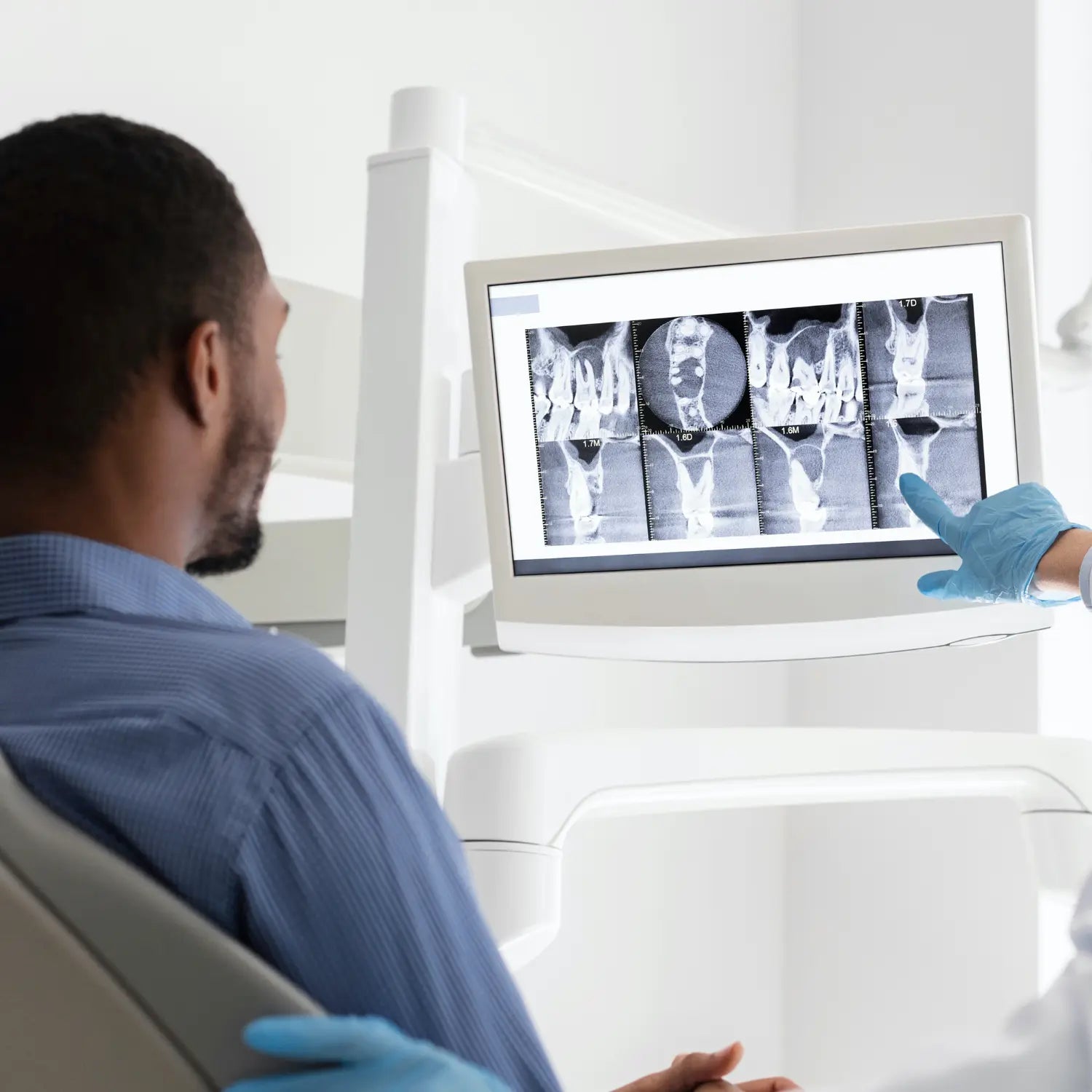 patient on a dental chait=r looking at an X-Ray