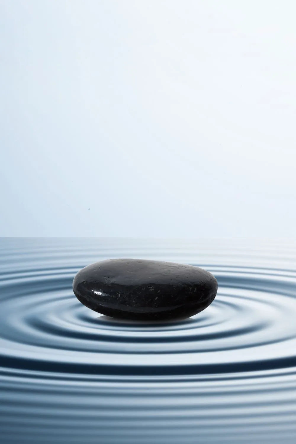 zen black stone on top of ripples of water